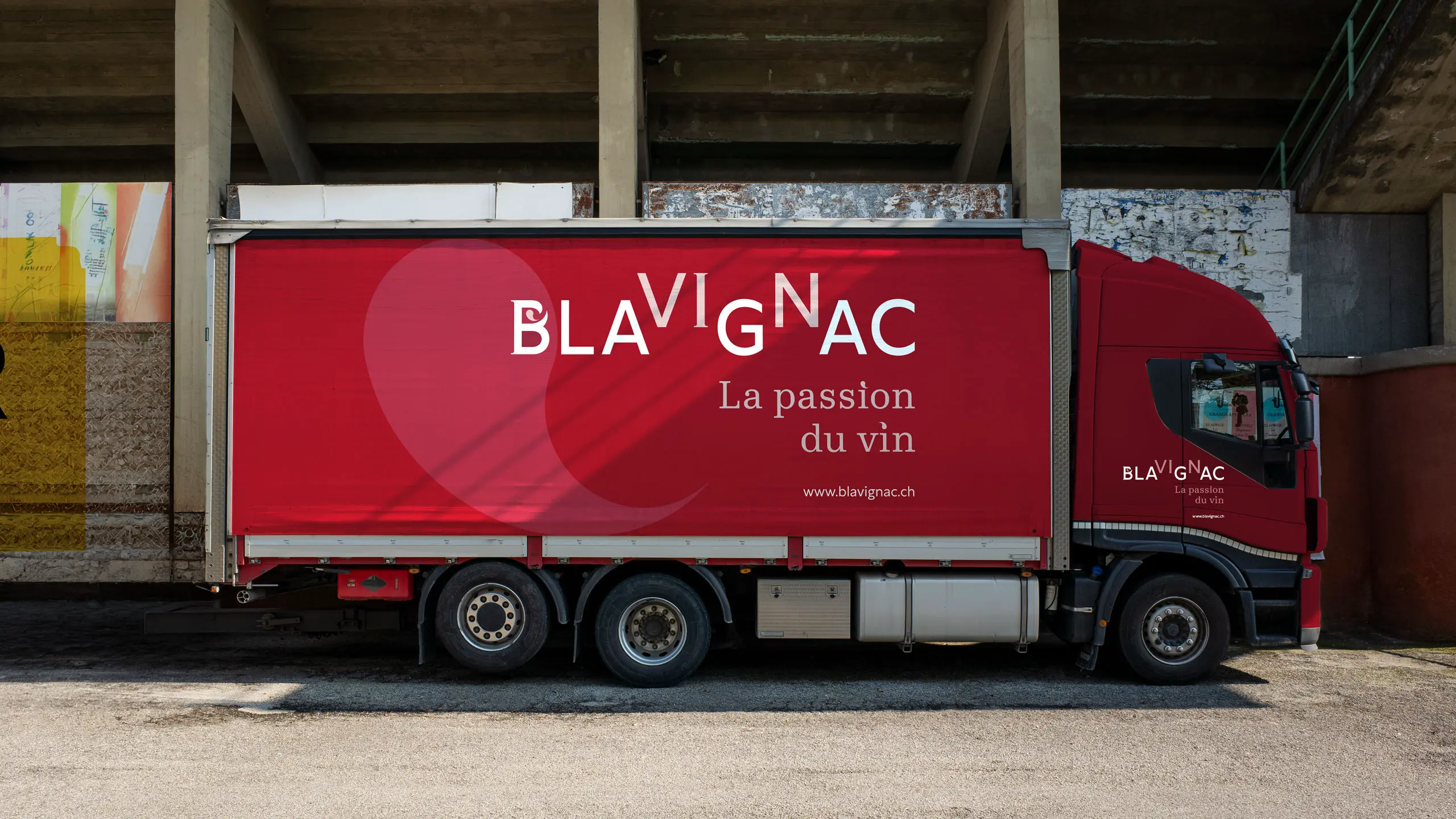 Camion de livraison Blavignac en rouge, logo et signature sur toute la bâche