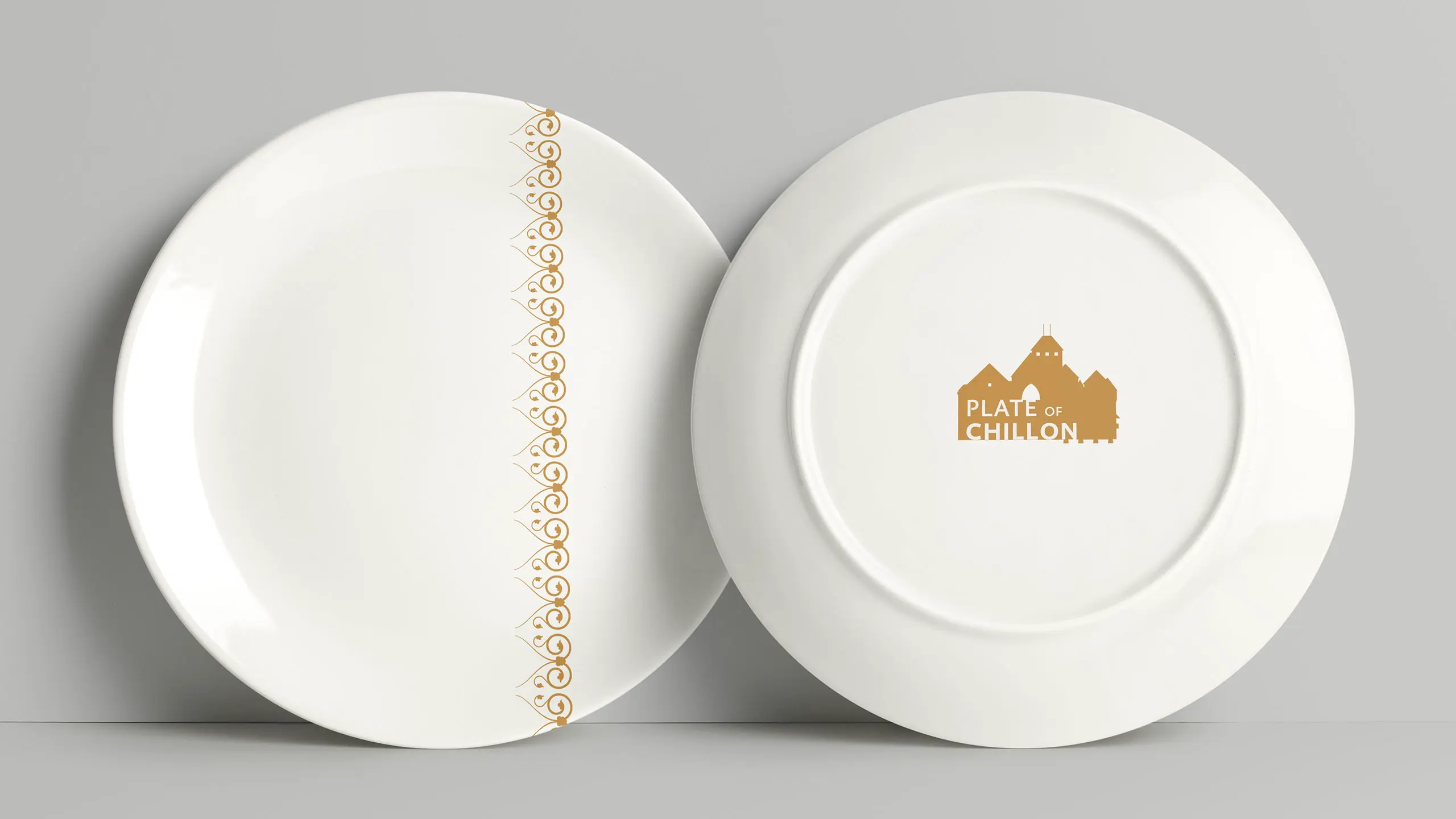 Assiettes « Plate of Chillon » à motif de ferronnerie doré, vues de face et de dessous
