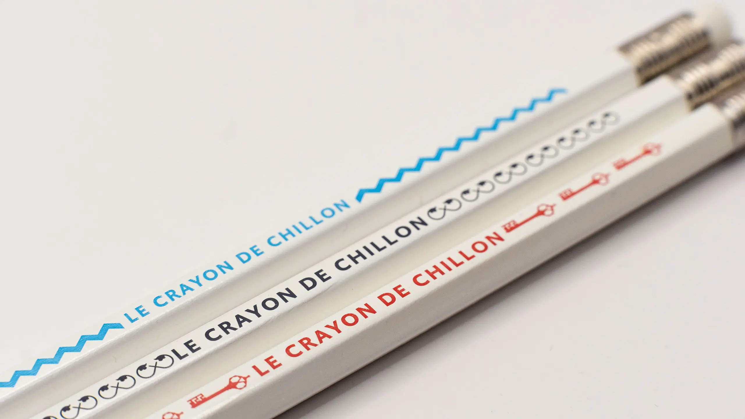 Trois crayons « Le Crayon de Chillon » ornés chacun d'un motif différent du système graphique