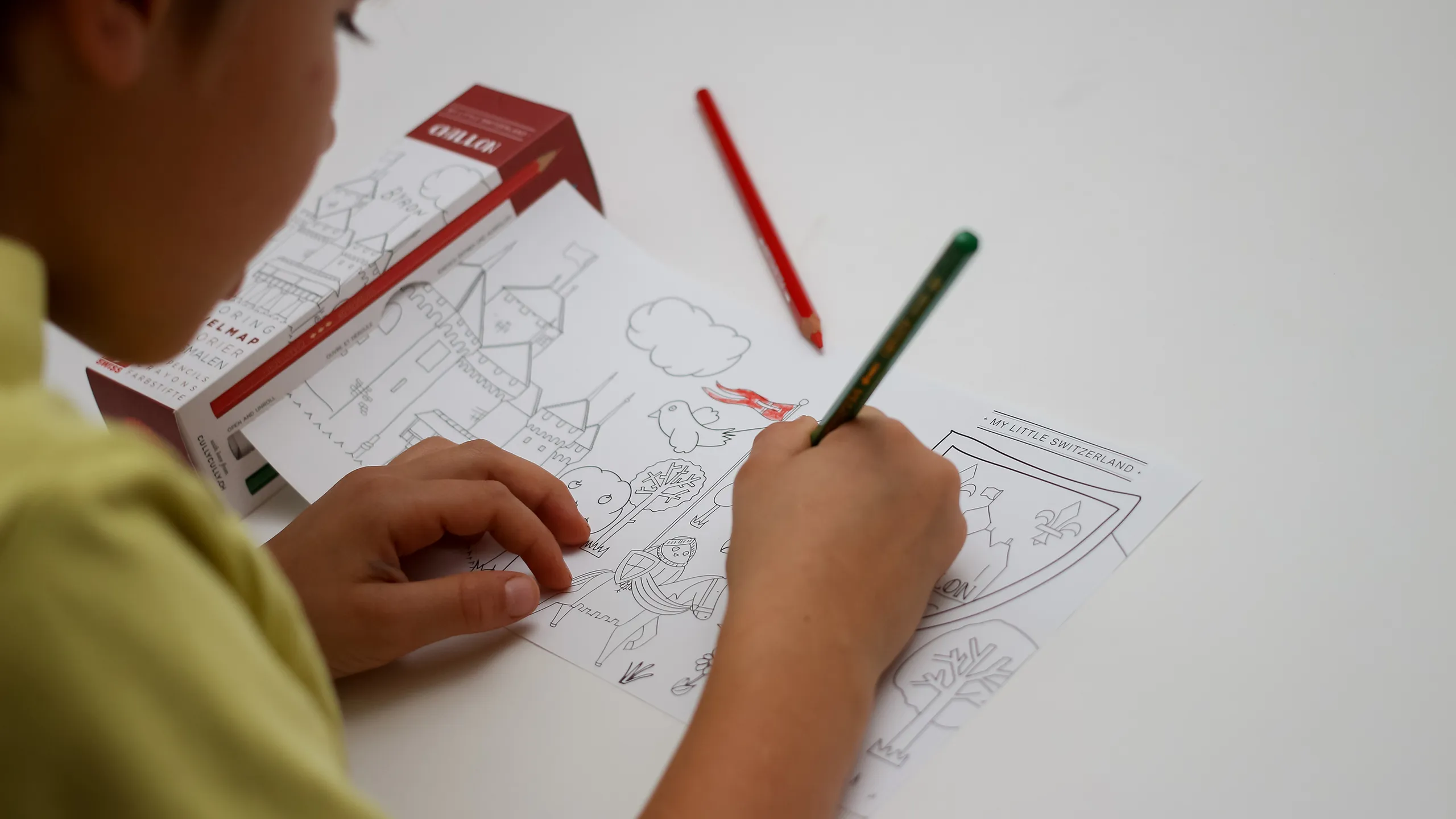 Enfant coloriant la TravelMap Chillon de CullyCully avec des crayons Caran d'Ache
