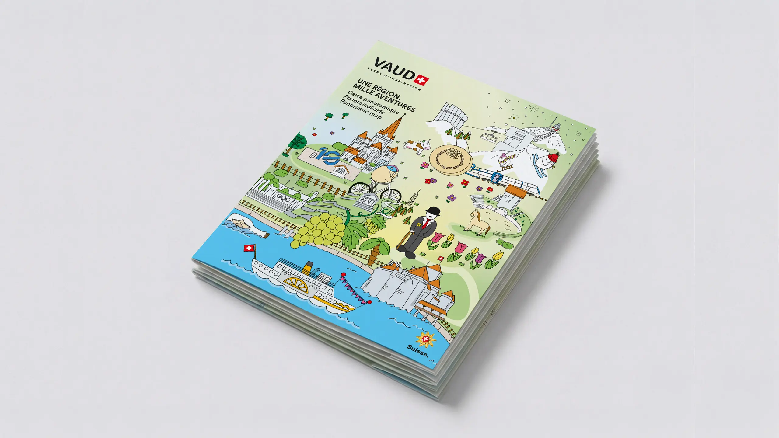 Couverture illustrée « Une région, mille aventures », carte panoramique du canton de Vaud, brochures pliées en pile.