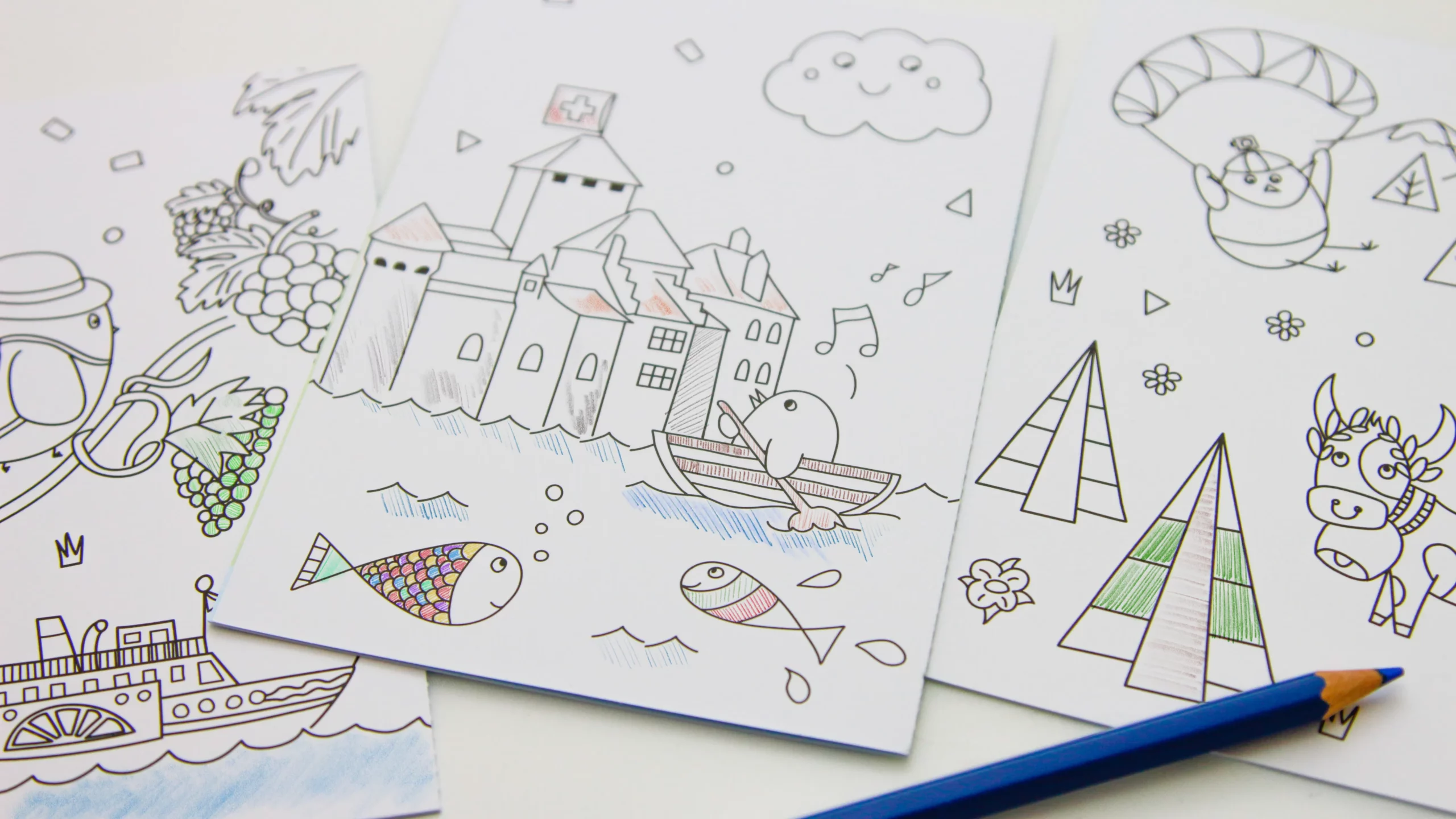 Versos des cartes postales transformés en coloriages : château de Chillon, bateau, poissons et sapins, en partie coloriés au crayon.