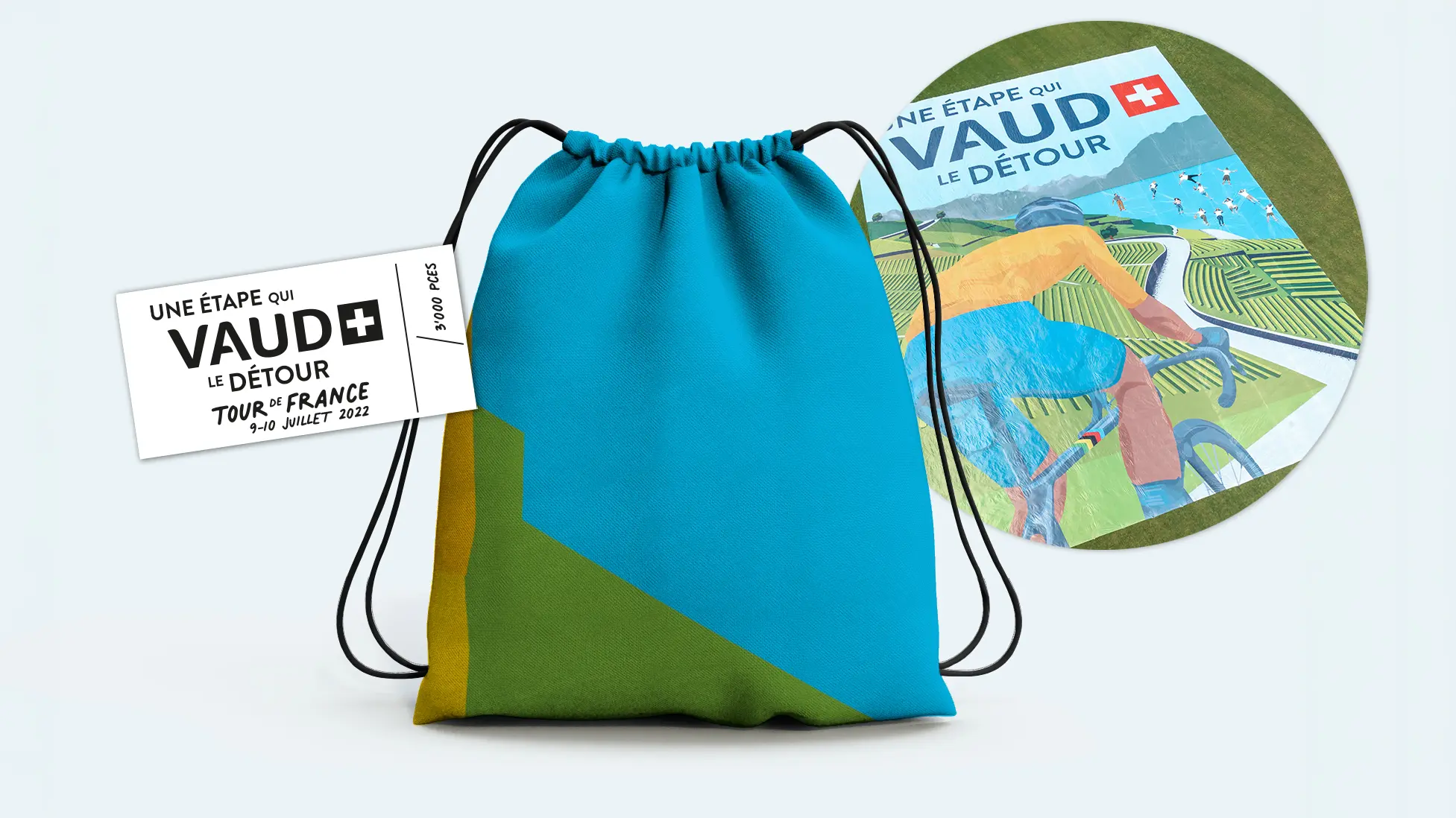 Sac de gym turquoise et vert confectionné à partir des bâches « Une étape qui Vaud le détour », avec étiquette Tour de France 2022 et vue de l'affiche.